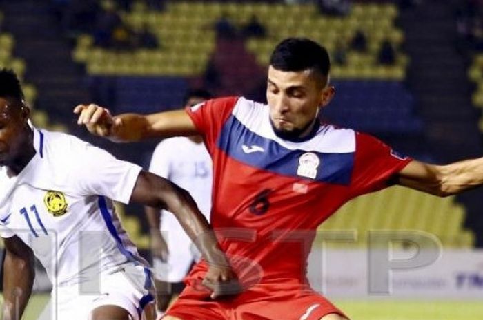 Penyerang naturalisasi timnas Malaysia, Mahamadou Sumareh (kiri) saat berhadapan dengan pemain Kirgistan pada laga FIFA Match Day di Stadion Hang Jebatm Melaka, 16 Oktober 2018. 