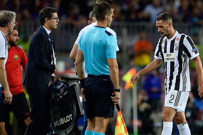 Bek Juventus, Mattia de Sciglio, meninggalkan lapangan akibat menderita cedera saat tampil melawan Barcelona dalam laga lanjutan Grup D Liga Champions 2017-2018 di Stadion Camp Nou, Barcelona, Spanyol, pada 12 September 2017.