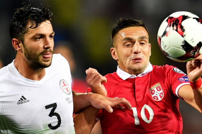 Gelandang tim nasional Serbia, Dusan Tadic (kanan), berduel dengan pemain Georgia, Davit Khocholava, dalam matchday terakhir Grup D babak Kualifikasi Piala Dunia 2018 zona Eropa di Stadion Rajko Mitic, Belgrade, Serbia, pada Senin (9/10/2017).