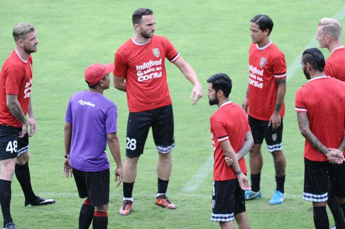 Pelatih Bali United, Widodo Cahyono Putro (topi) berdiskusi dengan para pemainnya sebelum latihan di Stadion Kapten I Wayan Dipta, Sabtu (6/1/2018).