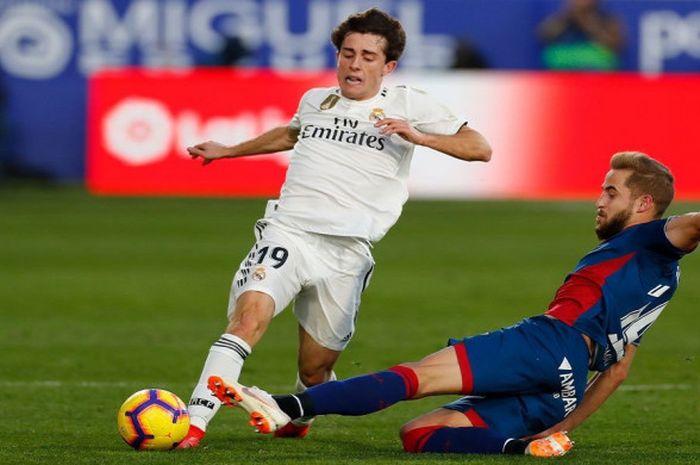 Bek Real Madrid, Alvaro Odriozola, menghindari adangan pemain SD Huesca, Jorge Pulido, dalam laga pe