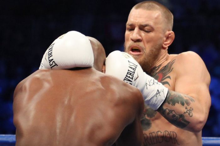 Floyd Mayweather mencoba merangsek ke pertahanan Conor McGregor saat keduanya bertarung, Sabtu (26/8/2017). 