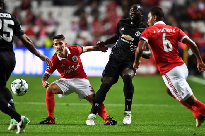  Aksi striker Manchester United, Romelu Lukaku (kedua dari kanan), saat mencoba melepaskan diri dari penjagaan dua pemain Benfica, Alex Grimaldo (kedua dari kiri) dan Filipe Augusto (kanan) dalam pertandingan Liga Champions 2017-2018 di Stadion Da Luz, Lisabon, Portugal, pada Rabu (18/10/2017). 