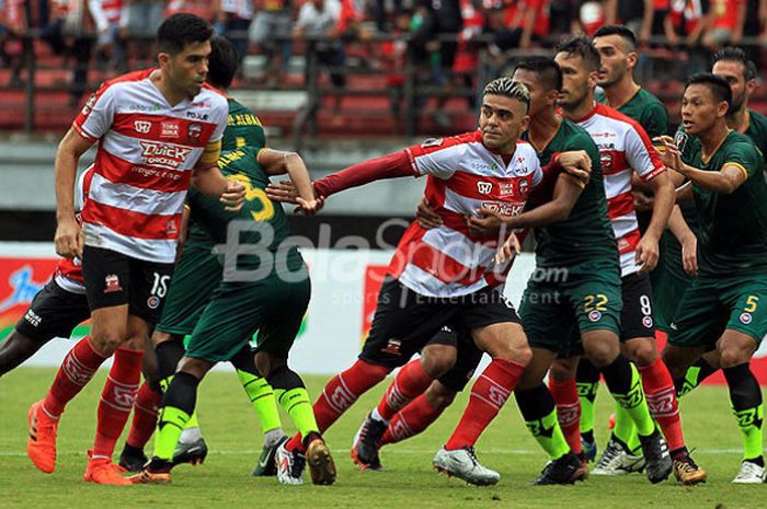 Pemain Madura United (merah-putih) dan PS TNI berebut posisi saat dilakukan tendangan bebas pada laga pekan kedua Piala Presiden 2018 Grup C di Stadion Gelora Bung Tomo Surabaya, Jawa Timur, Selasa (23/01/2018) sore.