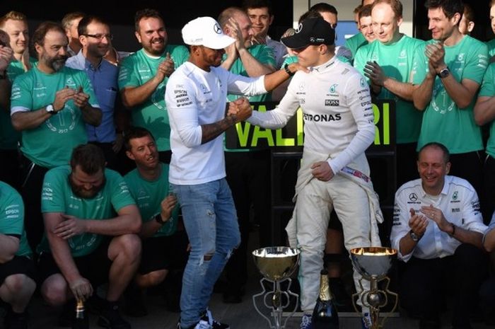  Pebalap Mercedes asal Finlandia, Valtteri Bottas, bersalaman dengan rekan setimnya, Lewis Hamilton, di sela perayaan kemenangan GP Rusia bersama para kru di Sochi Autodrom, Sochi, Rusia, Minggu (30/4/2017). 