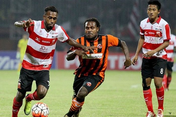 Gelandang Madura United, Engelberd Sani (kiri), berebut bola dengan gelandang Perseru Serui, Septinus Alua (tengah) pada laga kedua Grup E Piala Presiden 2017 di Stadion Gelora Ratu Pamelingan Pamekasan, Selasa (14/02/2017).