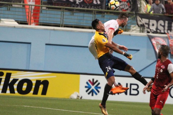 Duel udara antara kiper Home United, Rudy Khairulah (kuning) dengan striker Persija, Marko SImic pada laga leg pertama semifinal Piala AFC 2018 untuk zona ASEAN di Stadion Jalan Besar, Singapura, 8 Mei 2018. 