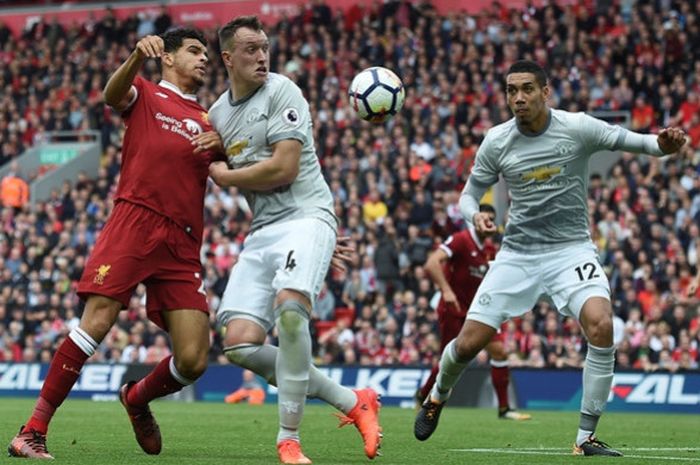 Penyerang Liverpool FC, Dominic Solanke (kiri), berduel dengan bek Manchester United, Phil Jones dan Chris Smalling, dalam laga Liga Inggris di Stadion Anfield, Liverpool pada 14 Oktober 2017.