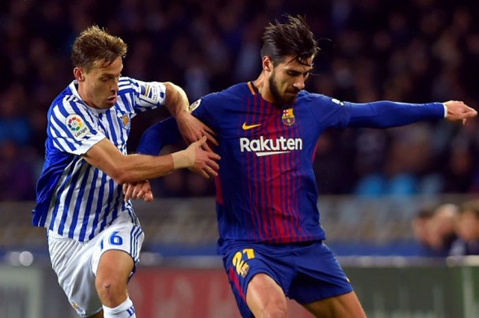 Gelandang FC Barcelona, Andre Gomes (kanan), berduel dengan pemain Real Sociedad, Sergio Canales, dalam laga Liga Spanyol di Stadion Anoeta, San Sebastian, pada 14 Januari 2018.