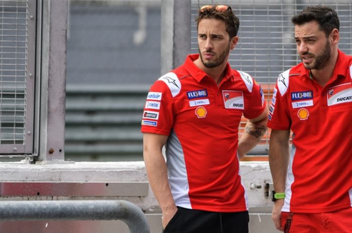 Pebalap Ducati, Andrea Dovizioso (kiri), terlihat sedang berbicara dengan salah satu anggota timnya pada hari pertama tes pramusim MotoGP 2018 di Sirkuit Internasional Sepang, Malaysia, Minggu (28/1/2018).