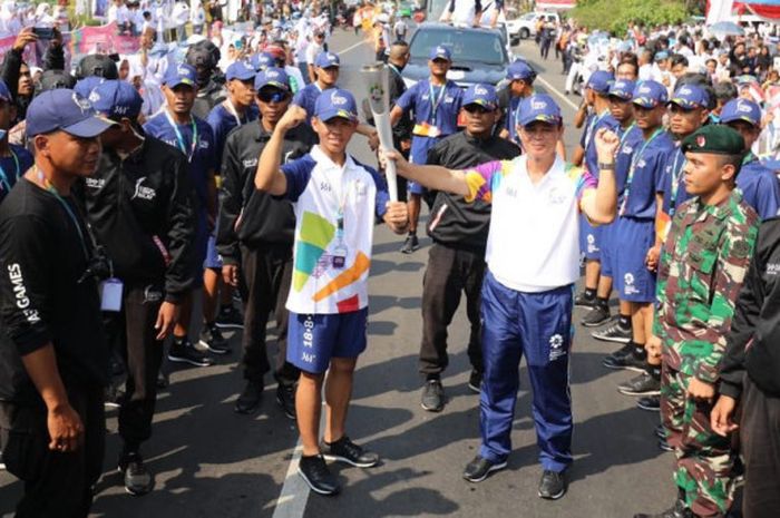 Sekretaris Daerah Cianjur, Abam Subandri (kanan), menyerahkan obor Asian Games kepada atlet judo junior, Aksal Muhammad Januar, jelang dimulainya kirab obor Asian Games 2018 di Stasiun Rawabango, Cianjur, Jawa Barat, Senin (13/8/2018).