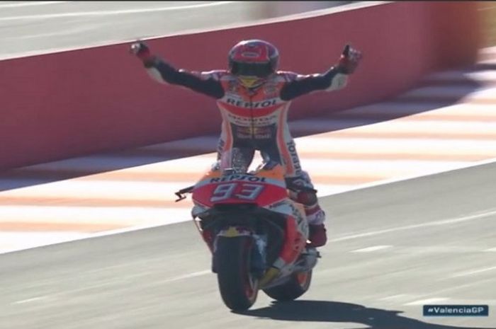 Selebrasi Marc Marquez sesaat sebelum melintasi garis finish balapan MotoGP Valencia, Minggu (12/11/2017).