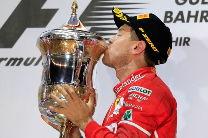 Pebalap Ferrari asal Jerman, Sebastian Vettel, mencium trofi seusai memenangi balapan GP Bahrain 201