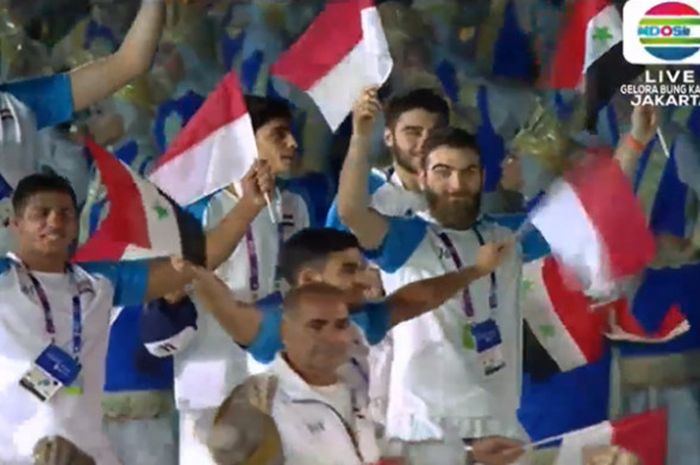 Kontingen Suriah turut mengibarkan bendera Indonesia saat melakukan defile pada pembukaan Asian Games 2018 di Stadion GBK, Jakarta, Sabtu (18/8/2018).