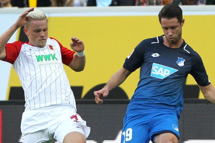 Philipp Max (kiri) dan Mark Uth berduel dalam partai Liga Jerman antara Augsburg dan Hoffenheim di Sinsheim, 14 Oktober 2017.