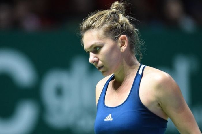 Petenis Rumania, Simona Halep, bereaksi saat menjalani pertandingan melawan Dominika Cibulkova (Slovakia) pada lanjutan laga penyisihan Grup Merah turnamen WTA Finals di Singapore Indoor Stadium, Singapura, Kamis (27/10/2016).