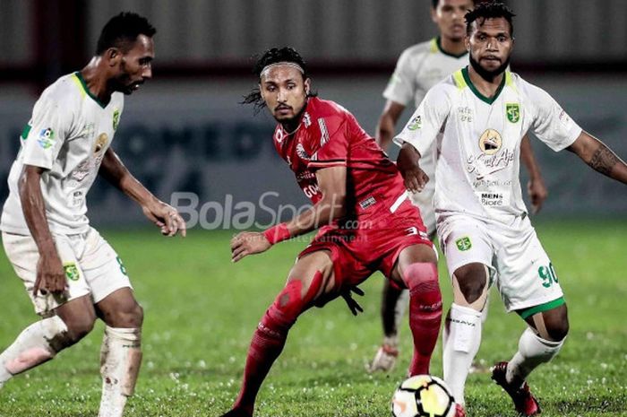 Gelandang Persija Jakarta, Rohit Chand, dikawal dua pemain Persebaya, Izaac Wanggai (kiri) dan Nelson Alom (kanan), di Stadion PTIK, Jakarta, Selasa (26/6/2018).