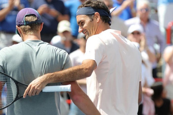 Roger Federer (kanan) menyapa lawannya, Peter Polansky, pada putaran kedua Rogers Cup, Rabu (9/8/2017)