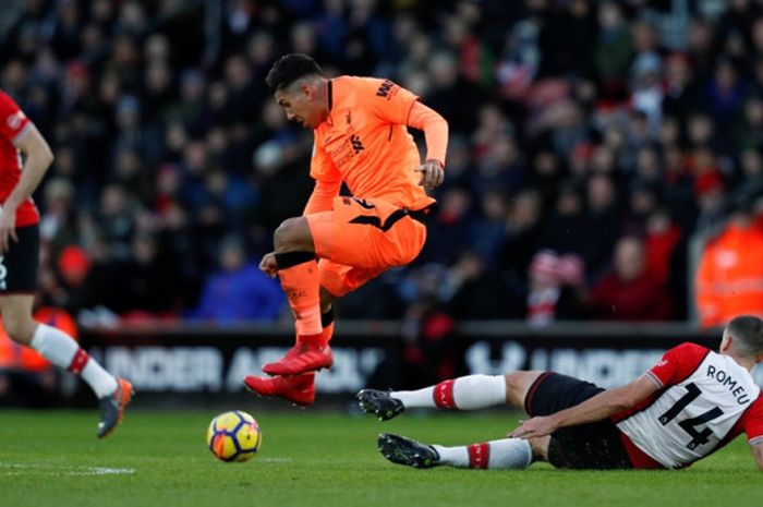 Striker Liverpool FC, Roberto Firmino (tengah), melompat dari hadangan gelandang Southampton, Oriol Romeu, dalam laga Liga Inggris di Stadion St. Mary's, Southampton, pada 11 Februari 2018.