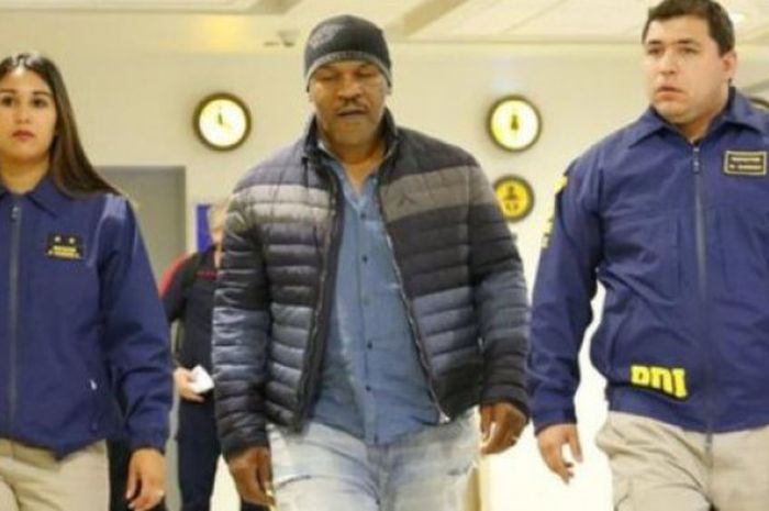 Mike Tyson dikawal dua polisi di bandara Santiago, Chile, Kamis (9/11/2017). 