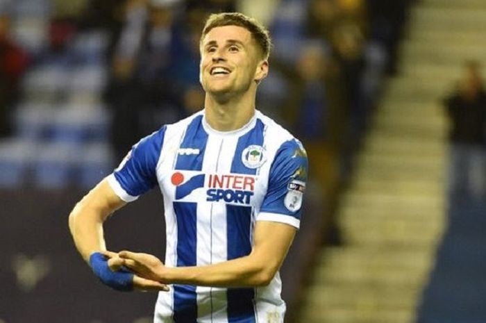 Winger Wigan Athletic, Ryan Colclough, berselebrasi seperti menggendong bayi usai mencetak gol ke gawang Doncaster Rovers pada Selasa (21/11/2017). Selebrasi itu ia tunjukkan karena di saat yang sama pasangannya melahirkan putra keduanya.