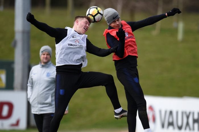  Gelandang Inggris, Dele Alli (kanan), berduel dengan bek Alfie Mawson dalam sesi latihan di St George's Park, Burton-on-Trent, Inggris, pada 20 Maret 2018. 