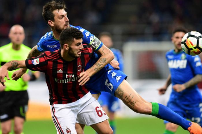 Striker AC Milan, Patrick Cutrone (depan), berduel dengan bek Sassuolo, Francesco Acerbi, dalam pertandingan Liga Italia 2017-2018 di Stadion San Siro, Milan, Italia, pada 8 April 2018.