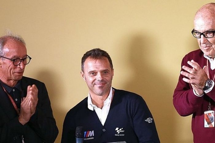 Mantan pebalap MotoGP asal Italia, Loris Capirossi (tengah), menerima sambutan dari Presiden FIM Vito Ippolito (kiri) dan CEO Dorna Sports, Carmelo Ezpeleta, saat diperkenalkan sebagai anggota Race Direction MotoGP di Sirkuit Ricardo Tormo, Valencia, Spanyol, Selasa (10/1/2017).