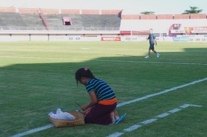 Wayan Sita meletakkan canang sari jelang tim nasional Indonesia U-22 berlatih di Stadion Kapten I Wayan Dipta, Gianyar, Senin (23/5/2017).