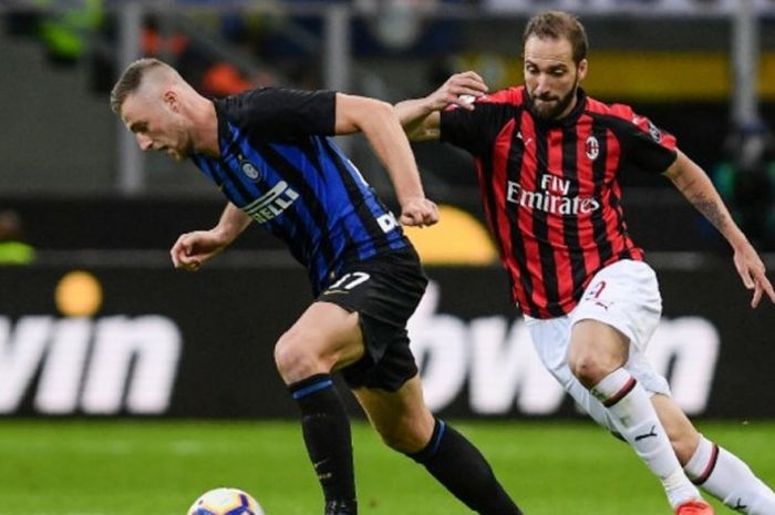 Gonzalo Higuain (kanan) membayangi bek Milan Skriniar  dalam partai Liga Italia antara Inter Milan vs AC Milan di Giuseppe Meazza, 21Oktober 2018.