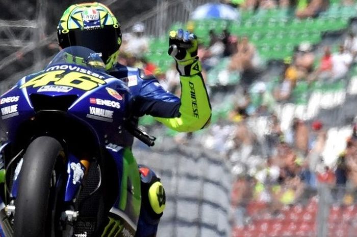 Pebalap Movistar Yamaha asal Italia, Valentino Rossi, melakukan waves seusai menjalani sesi latihan hari pertama GP Italia di Sirkuit Mugello, Jumat (2/6/2017).