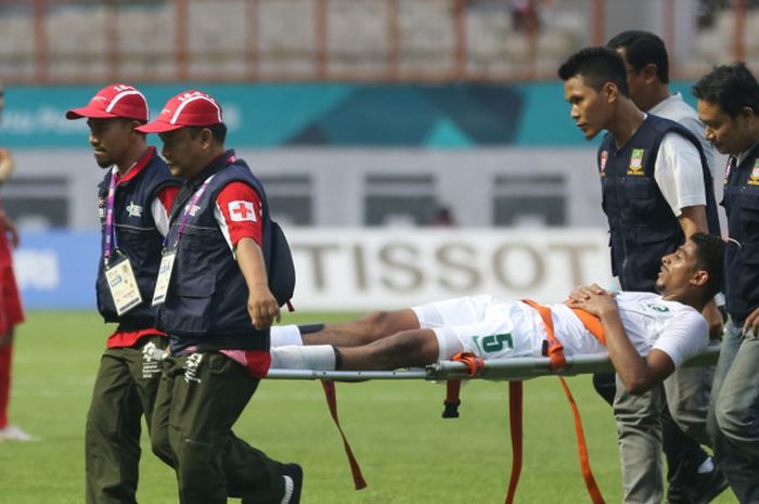 Bek timnas U-23 Arab Saudi, Abdulelah Al-Amri, ditandu meninggalkan lapangan dalam laga Grup F Asian Games 2018 kontra Iran di Stadion Wibawa Mukti, Cikarang, Rabu (15/8/2018).