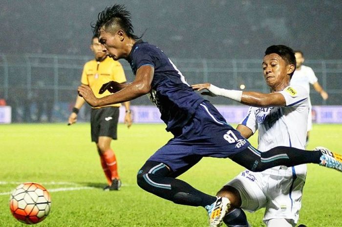 Bek Arema Cronus, Johan Alfarizi (kiri), terjatuh setelah ditekel gelandang Persib Bandung, Febri Haryadi, saat kedua tim bertemu di pekan ke-34 Torabika Soccer Championship 2016 di Stadion Kanjuruhan Malang, Jawa Timur (18/12/2016).