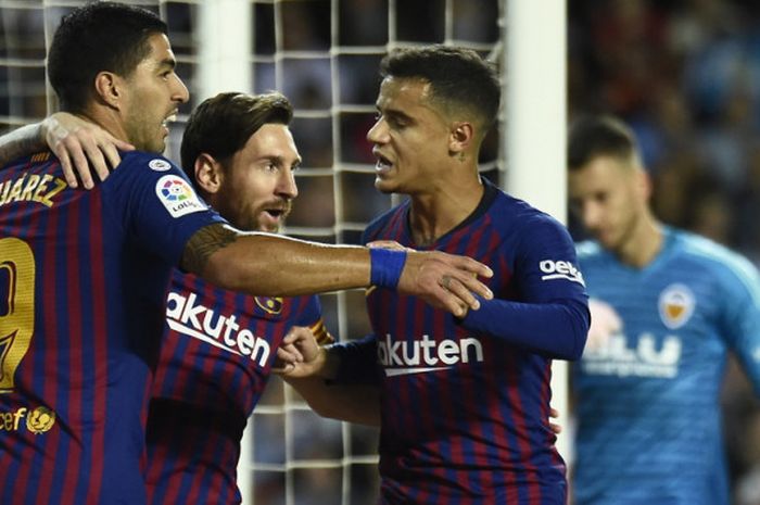 Penyerang Barcelona, Lionel Messi (tengah), saat merayakan gol bersama Luis Suarez (kiri) dan Philippe Coutinho seusai membobol gawang Valencia dalam pertandingan Liga Spanyol 2018-2019 di Stadion Mestalla, Valencia, Spanyol, pada Minggu (7/10/2018).