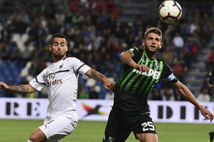 Aksi striker Sassuolo, Domenico Berardi (kanan), saat berduel dengan gelandang serang AC Milan, Suso, dalam laga Liga Italia 2018-2019 di Stadion MAPEI, Reggio Emilia, Italia, pada Minggu (30/9/2018).