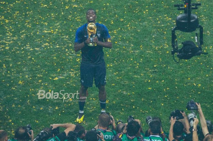 Gelandang Prancis, Paul Pogba, berpose dengan trofi juara Piala Dunia 2018 setelah timnya menekuk Kroasia 4-2 pada laga final di Stadion Luzhniki, Moskow, 15 Juli 2018.