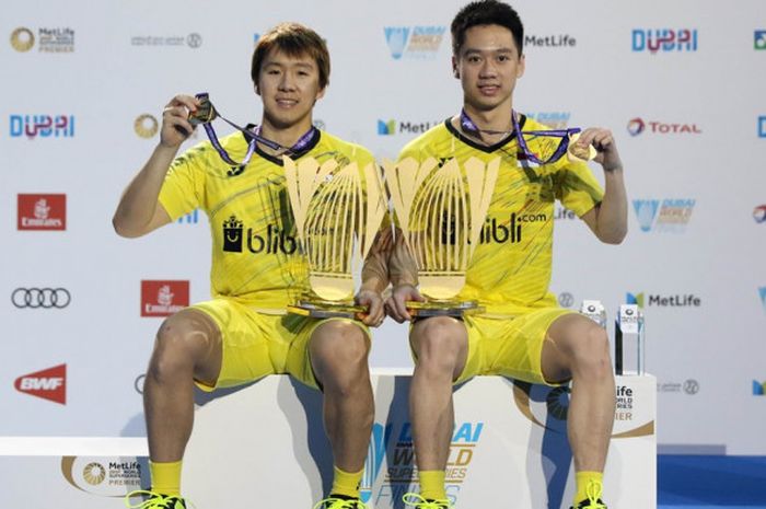 Pasangan ganda putra Indonesia, Marcus Fernaldi Gideon (kanan)/Kevin Sanjaya Sukamuljo, berpose dengan trofi dan medali yang mereka raih seusai menjuarai turnamen BWF Superseries Finals 2017 di Hamdan Sports Complex, Dubai, Uni Emirat Arab, Minggu (17/12/2017).