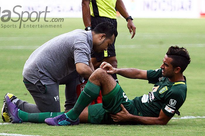 Otavio Dutra menerima perawatan dari tim medis Persebaya saat mengalami cedera.