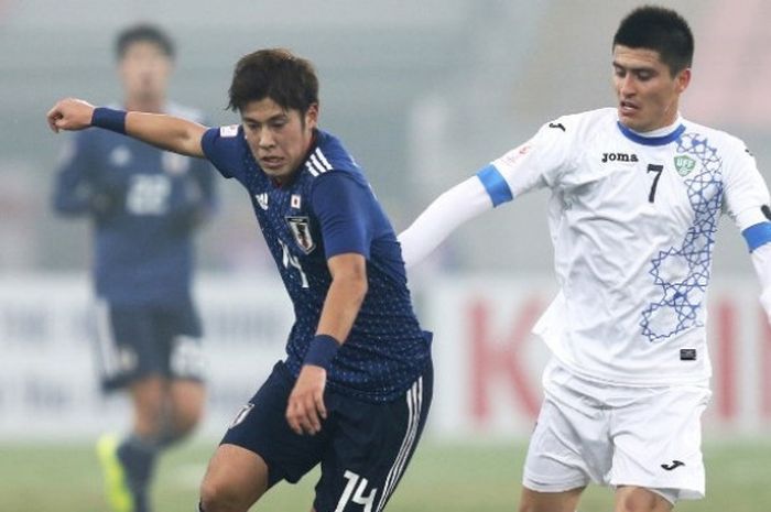 Pemain timnas U-23 Jepang, Shion Inoue (kiri) berebut bola dengan pemain Uzbekistan dalam laga Piala Asia U-23 2018 di Stadion Jiangyin pada Jumat (19/1/2018).