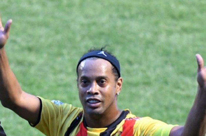 Mantan bintang Barcelona dan timnas Brasil, Ronaldinho Gaucho, melambaikan kedua tangannya pada penonton di laga amal 