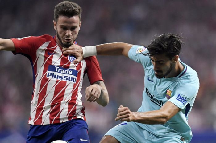 Aksi gelandang Atletico Madrid, Saul Niguez (kiri), berduel dengan pemain FC Barcelona, Andre Gomes, dalam pertandingan La Liga Spanyol 2017-2018 di Stadion Wanda Metropolitano, Madrid, Spanyol, pada Sabtu (14/10/2017).