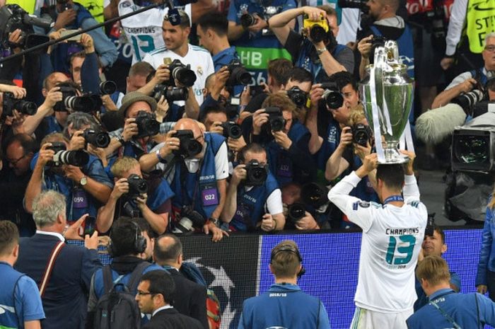     Megabintang Real Madrid, Cristiano Ronaldo, berpose dengan mengangkat trofi Liga Champions seusai mengalahkan Liverpool FC dalam laga final di Stadion NSC Olimpiyskiy, Kiev, Ukraina pada 26 Mei 2018.    