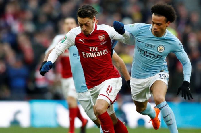 Gelandang Arsenal, Mesut Oezil (kiri), berduel dengan pemain Manchester City, Leroy Sane, dalam laga final Piala Liga Inggris di Stadion Wembley, London, pada 25 Februari 2018.