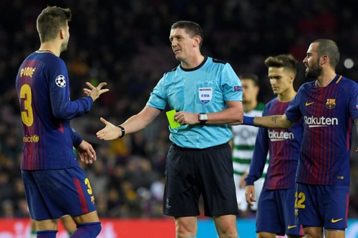 Bek FC Barcelona, Gerard Pique (kiri), berbicara dengan wasit Craig Thomson, dalam laga Grup D Liga Champions kontra Sporting CP di Stadion Camp Nou, Barcelona, Spanyol, pada 5 Desember 2017.