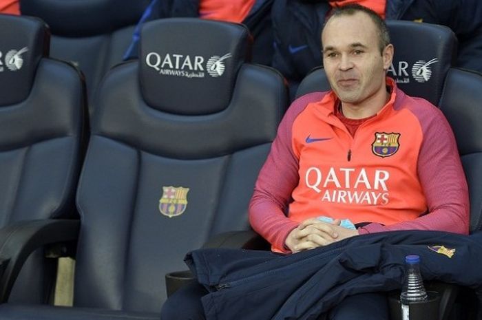 Gelandang FC Barcelona, Andres Iniesta, duduk di bangku sisi lapangan menjelang laga La Liga kontra Real Madrid di Stadium Camp Nou, 3 Desember 2016.