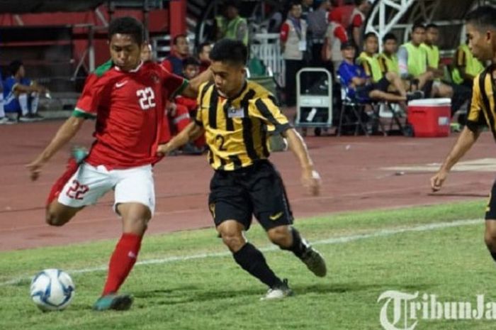 Pemain belakang timnas U-16 Indonesia Muhammad Fajar Fathurahman (kiri) menendang bola saat berhadapan dengan timnas U-16 Malaysia di semifinal Piala AFF U-16 2018.