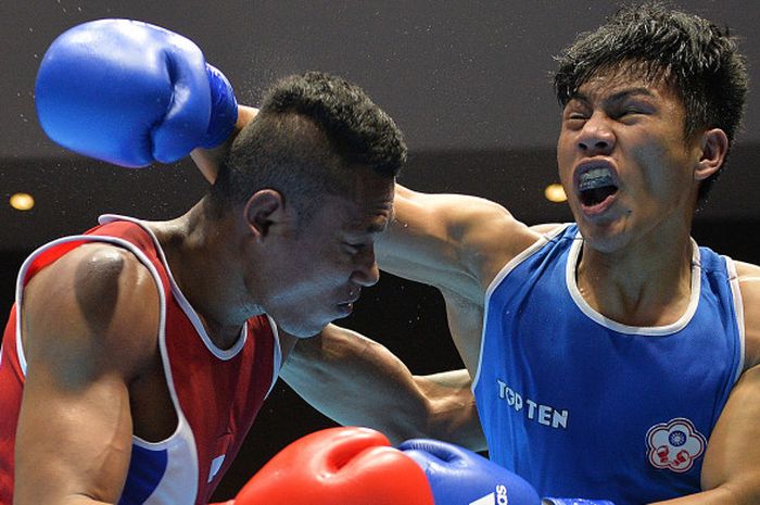 Petinju Indonesia, Brama Henda Betaubun (kiri), dan petinju Taiwan Kan Chia Wei (kanan) saling melepaskan pukulan saat laga perempat final kelas Men's Middle (75 kg) pada 18th Asian Games Invitation Tournament di JIExpo, Kemayoran, Jakarta, Senin (12/2/2018).