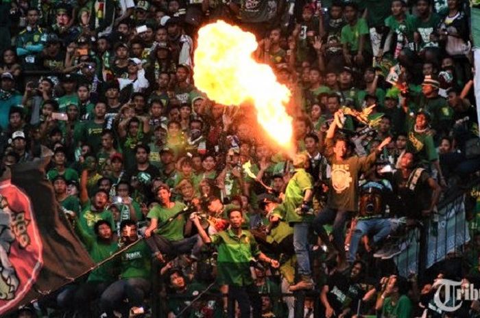 Pendukung Persebaya Surabaya menampilkan aksinya saat timnya melawan Arema Malang dalam pertandingan lanjutan Liga 1 di Stadion Gelora Bung Tomo Surabaya, Minggu (6/5/2018). Tuan rumah Persebaya Surabaya mengalahkan Arema Malang melalui gol tunggal Misbakus Solikin. 