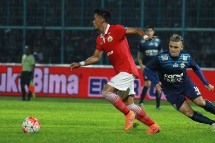 Striker Arema, Cristian Gonzales mencoba merebut bola dari penguasaan bek Persija, Maman Abdurahman 