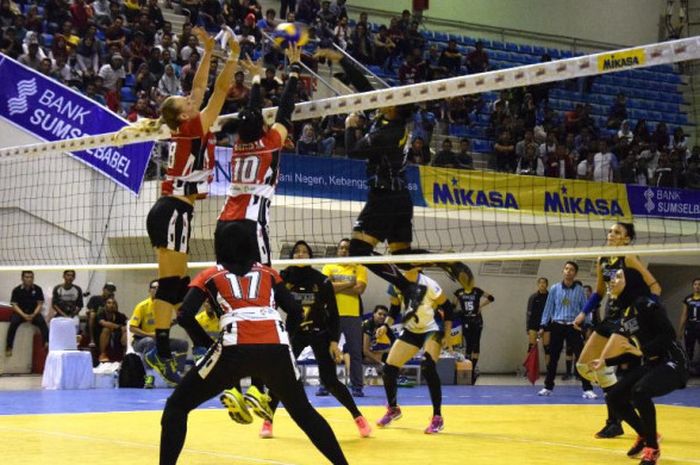 Pemain tim bola voli putri Jakarta Pertamina Energi (jersey merah) berusaha menahan smes dari Aprilia Manganang (Bandung Bank BJB Pakuan) pada putaran kedua seri kedua Proliga 2018 di GOR PSCC, Palembang, Minggu (11/3/2018).